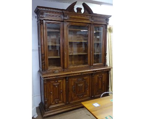 A large Antique Continental walnut 2-section bookcase, of architectural form, the top having 3 glazed cupboard doors with adj