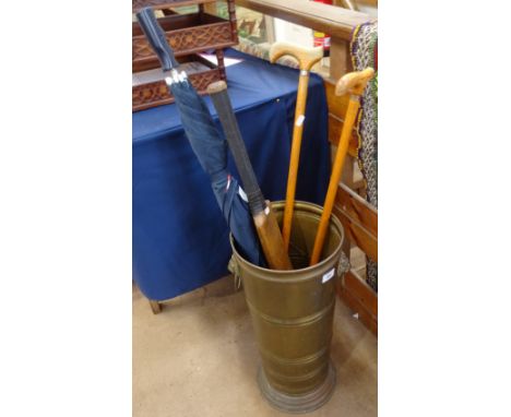 A brass stick stand with lion mask ring handles, an umbrella, sticks, and a Dreadnought cricket bat 