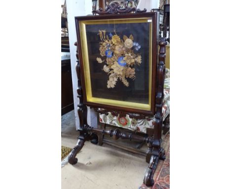 A 19th century rosewood firescreen, with a floral decorated glazed panel, raised on pierced supports, W122cm 