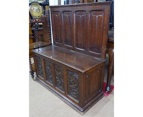 An Antique carved and linenfold oak hall bench, with rising seat, W103cm, H112cm 