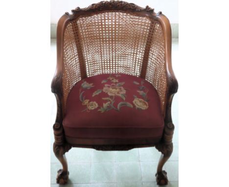 Walnut bergere backed tub style armchair with carved decoration, tapestry seat and on ball and claw supports. Approx. 85cms H
