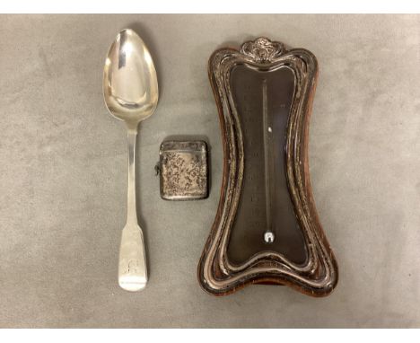 A collection of sterling silver items to include a silver mounted easel backed desk top thermometer, a Georgian serving spoon