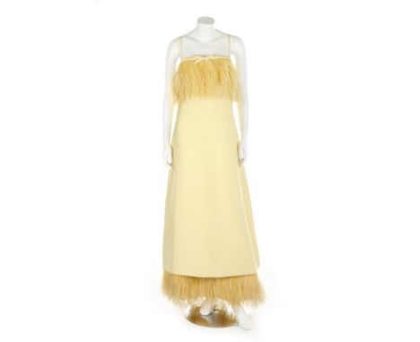 A yellow gazar evening dress, circa 1967, labelled 'made in France', trimmed with ostrich feathers to bodice and hem, bust 86