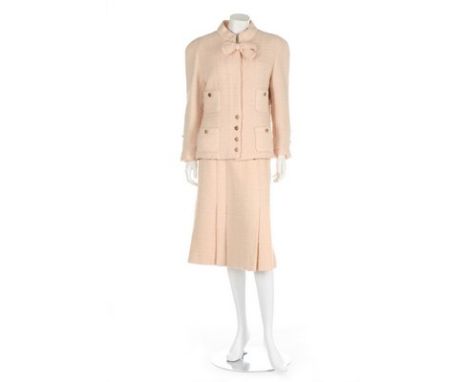 A Chanel couture pale pink tweed suit, late 1970s, labelled and numbered 63297-9, the jacket with gilt double 'C' buttons and