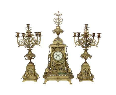 antique brass garniture with a pair of candelabra and a clock  || Antieke driedelige schouwgarnituur in koper met een paar ka