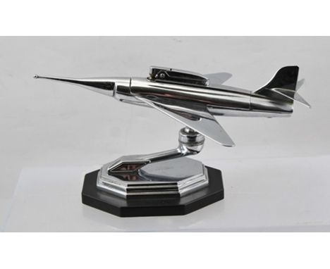A CHROME PLATED JET FIGHTER DESIGN TABLE LIGHTER, on pivot stem and ebonised base, bears various patent nos. 