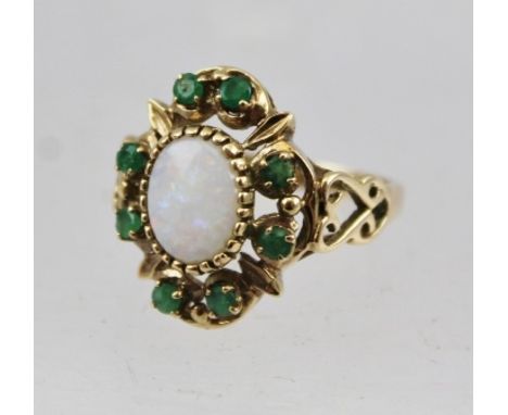 A 9CT GOLD LADY'S DRESS RING inset central oval opal surrounded by emeralds, size N easy 