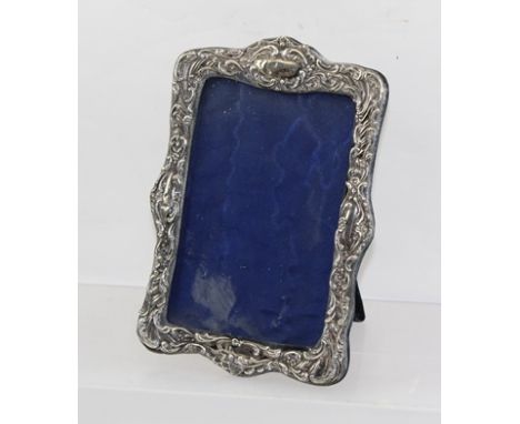 MARKS OBSCURED AN EDWARDIAN FANCY RECTANGULAR EMBOSSED SILVER PHOTOGRAPH FRAME with blue velvet easel back, Chester 1903, 18 