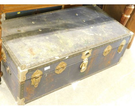 A rectangular travel trunk, in blue with exterior studding and brass mounts.