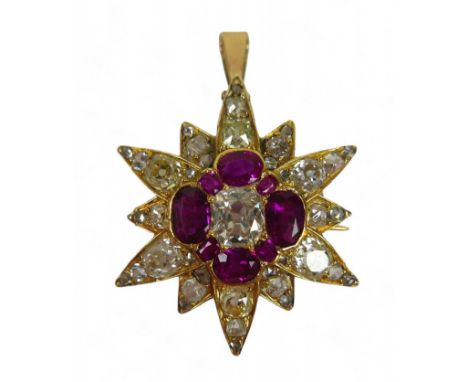 A diamond and ruby star form pendant/brooch, with central elongated cushion cut diamond, 5 by 6mm, surrounded by over thirty 