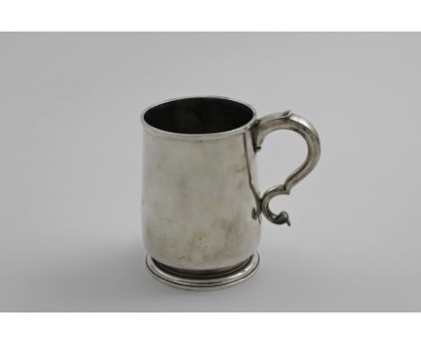 A GEORGE I BRITANNIA-STANDARD MUG with a slightly tapering body, a tucked-in base with a domed circular foot and a double scr