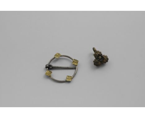 AN ELIZABETH I SILVERGILT CLOTHING HOOK OR FASTENER trefoil shaped and domed, with a flowerhead motif in the centre, together