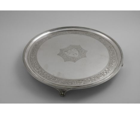 A GEORGE III CIRCULAR SALVER with a reeded rim and bracket feet, decorated around the border with a bright-cut frieze and in 
