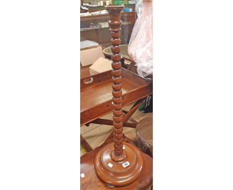An 80cm high late Victorian polished oak candle stand with brass nozzle, bobbin turned pillar and loaded circular base 