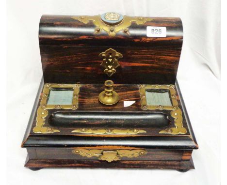 A coromandel escritoire with brass detailing and central brass candle holder, the lift up stationery compartment lid with cer