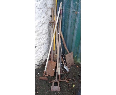 A selection of long handled garden tools, two shovels and a fork, etc.