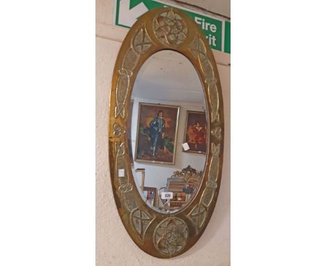 A vintage Scottish Arts &amp; Crafts Celtic design embossed brass clad framed bevelled oval wall mirror