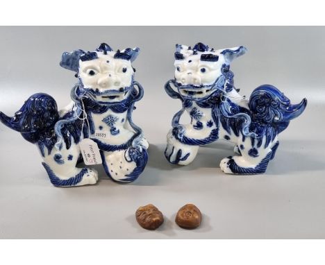Mirror matched pair of blue and white 20th century modern Fo Dogs, the female with a pup beneath her foot and the male with a