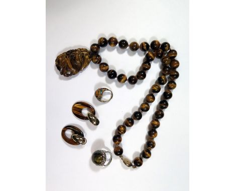 A Chinese Tiger's Eye Bead Necklace with carved pendant, pendant 52mm, 18mm beads, 65cm long, silver gilt filigree and enamel