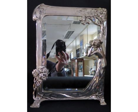'The First Cuckoo' _ A W.M.F. Silvered German Art Nouveau Easel Back Toilet Mirror decorated with a maiden cupping her hand b