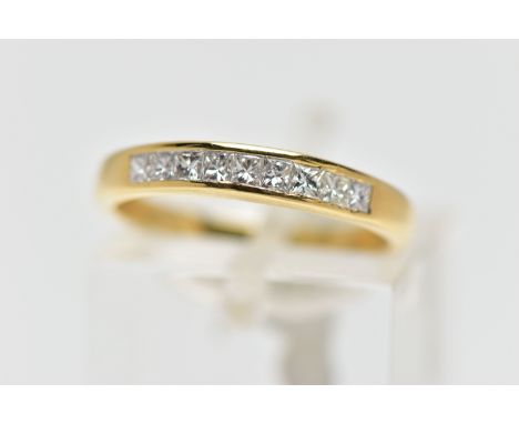 AN 18CT GOLD DIAMOND NINE STONE RING, channel set with graduated princess cut diamonds to the tapered band, estimated total d