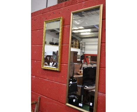 A gilt framed mirror, 106cm x 40cm; an ornate gilt framed mirror, bevelled edge 35cm x 66cm 