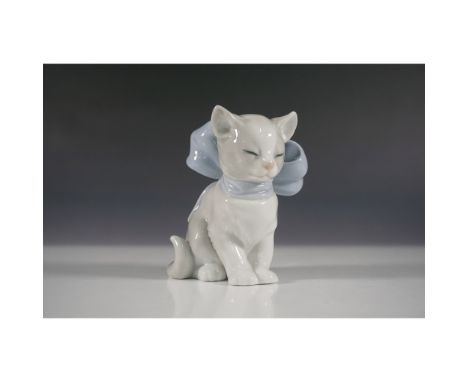 Charming porcelain figurine featuring a seated cat adorned with a large blue bow. This delicate piece captures the sweet and 