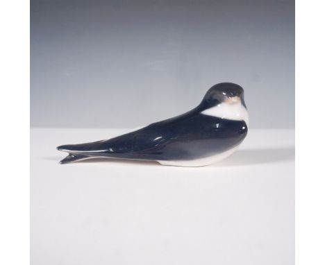 This Royal Copenhagen bird figurine, depicts a sleek, elegant bird in a tranquil stance. The figurine is beautifully crafted 