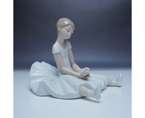 This Nao porcelain figurine, titled "Dreamy Ballet" (1456), features a graceful young girl seated with her legs crossed, gent