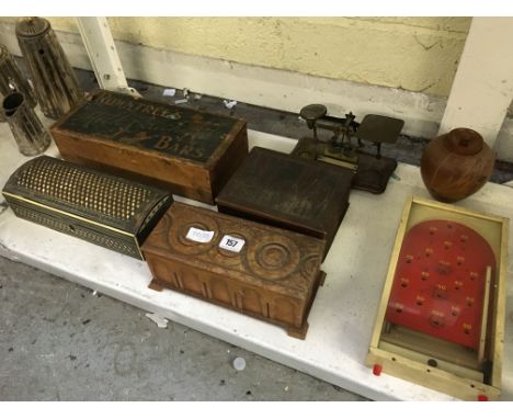 A collection of various boxes together with a set of postal scales and a toy Bagatelle board.