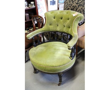 A late Victorian ebonised and gilt tub shape armchair with spindle back, button upholstered in a green velvet