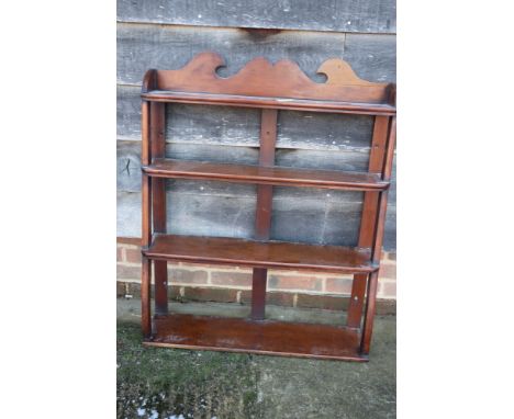 An early 19th century mahogany three-tier open wall shelf with shaped sides, 30" wide