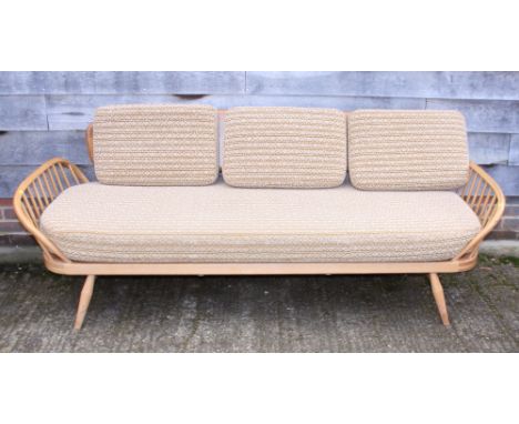 An Ercol panel back three-seat settee with spindle arms, 80" wide (recently restored)