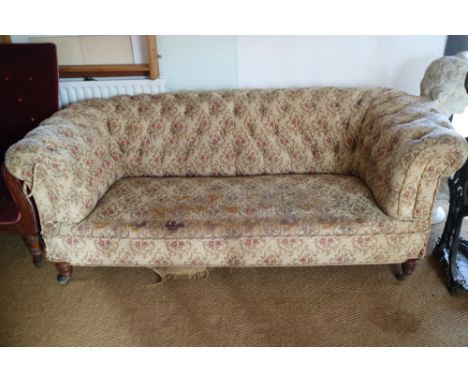 A Victorian chesterfield settee, button upholstered in a floral tapestry, on turned supports