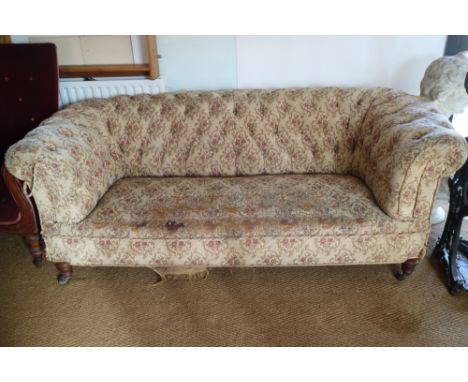 A Victorian chesterfield settee, button upholstered in a floral tapestry, on turned supports