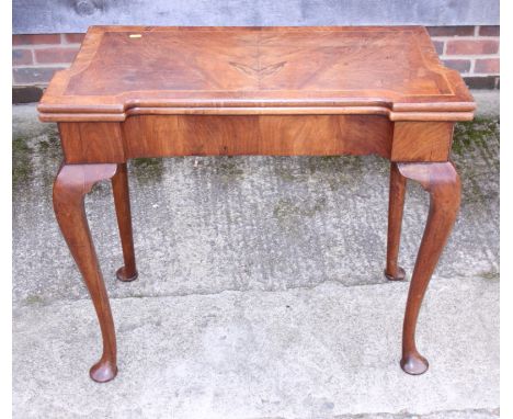 A Georgian figured walnut fold-over top card table with single gate action, on cabriole supports and pad feet, 32" wide