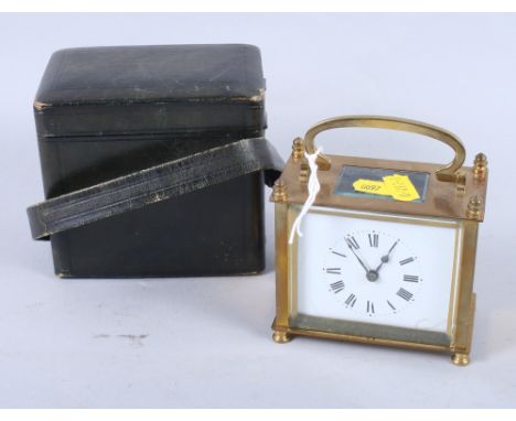 A brass cased carriage clock with white enamel dial, 3 1/2" high x 4" wide, in leather travel case