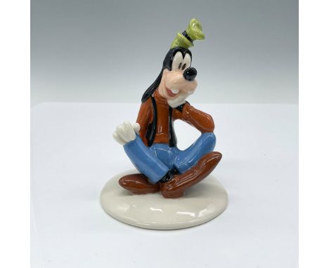 Goofy figurine crafted in porcelain, dressed in his traditional outfit of blue pants, black vest, and brown shirt. Part of th