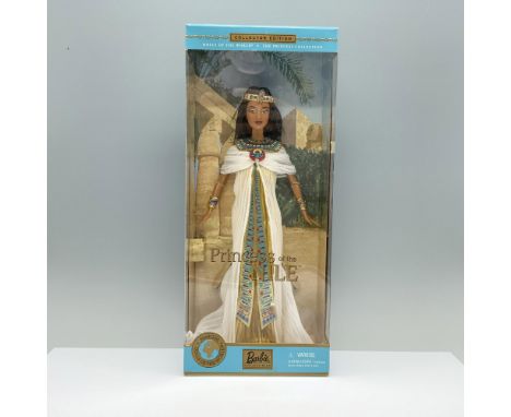 A stunning doll in a Pharaoh's ensemble of white and gold fabric, complemented by a gold-colored crown and neck piece. Marked