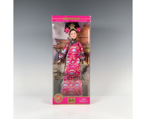 Dressed in a resplendent pink Chinese gown adorned with delicate flowers, her hair adorned with matching blossoms and topped 