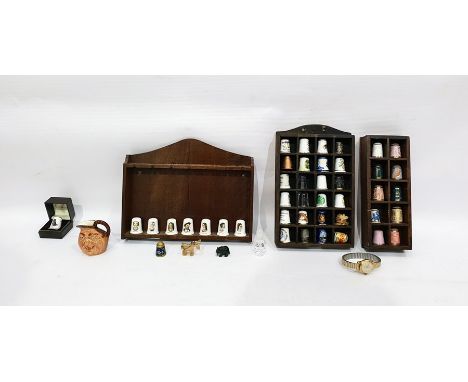Collection of ceramic, glass and other thimbles in display stands, miniature John Barleycorn character jug and a watch 