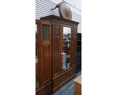 Edwardian walnut wardrobe, the mirrored door flanked by panelled sides over one long drawer and on plinth base, 130cm wide to