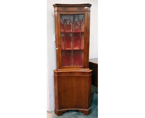 20th century yew concave corner cupboard with astragal glazed door, enclosing shelves, cupboard door under, to bracket feet 