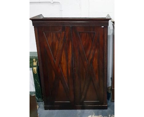 Late 19th century mahogany two-door wardrobe with blind carved surround and panelled doors with applied mouldings, on plinth 