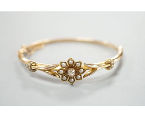 An early 20th century yellow meta diamond and seed pearl set hinged bangle, gross 9.5 grams.