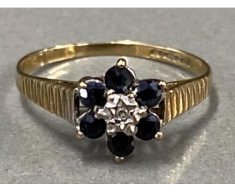 9CT YELLOW GOLD CLUSTER RING WITH DIAMOND CENTRE STONE SURROUNDED BY 6 BLUE STONES, 1.2G SIZE J