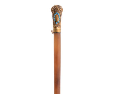  A Victorian gilt metal mounted rhinoceros horn riding crop,   late 19th century, the foliate embossed grip set with paste tu