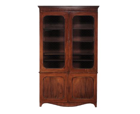  A Regency mahogany library bookcase  , circa 1815, the moulded cornice above a pair of brass grilled panel doors enclosing a