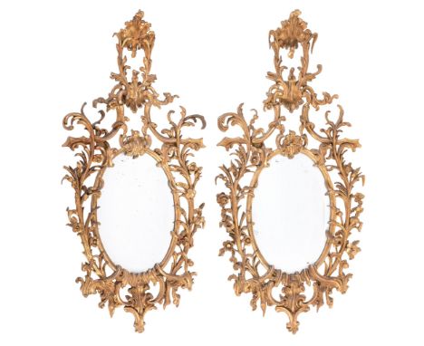 A pair of giltwood oval wall mirrors in George III style  , 19th century, each with raised surmount and pierced foliate scro