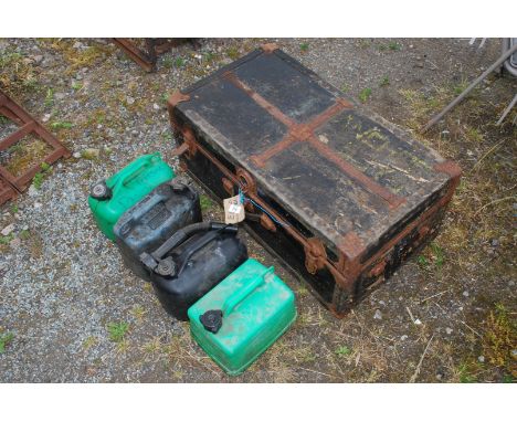 An old trunk and four plastic fuel cans